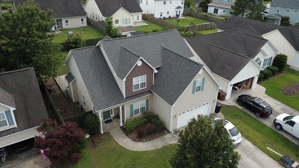 An aerial view of a house in a residential neighborhood