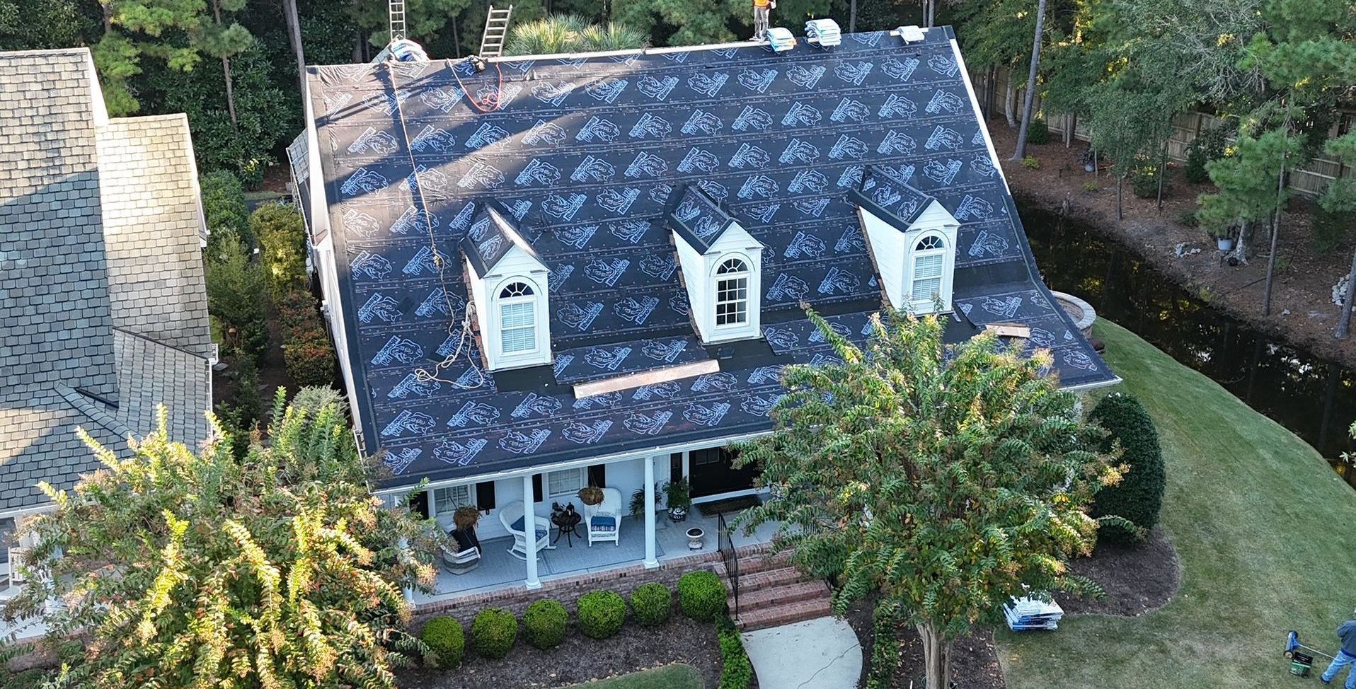 An aerial view of a house with a new roof being installed.