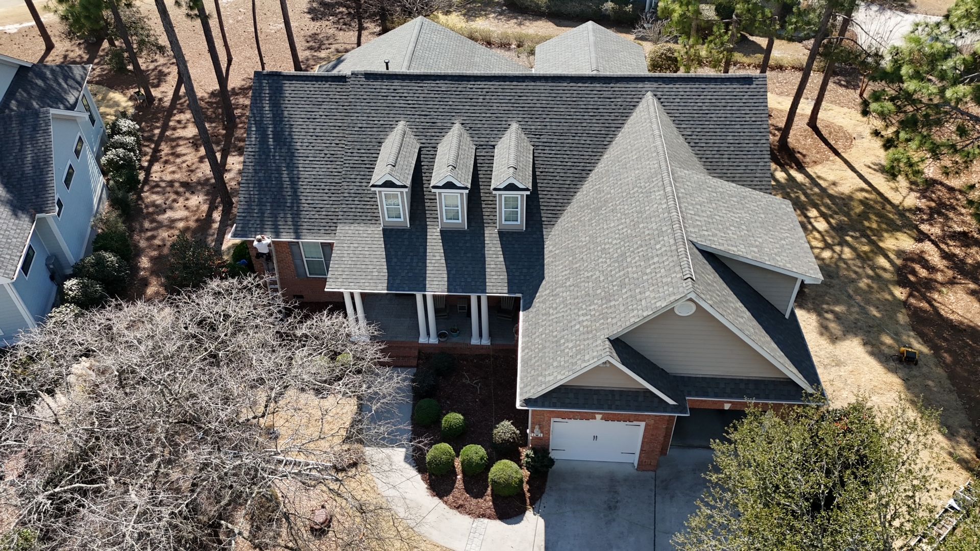 An aerial view of a house with a gray roof