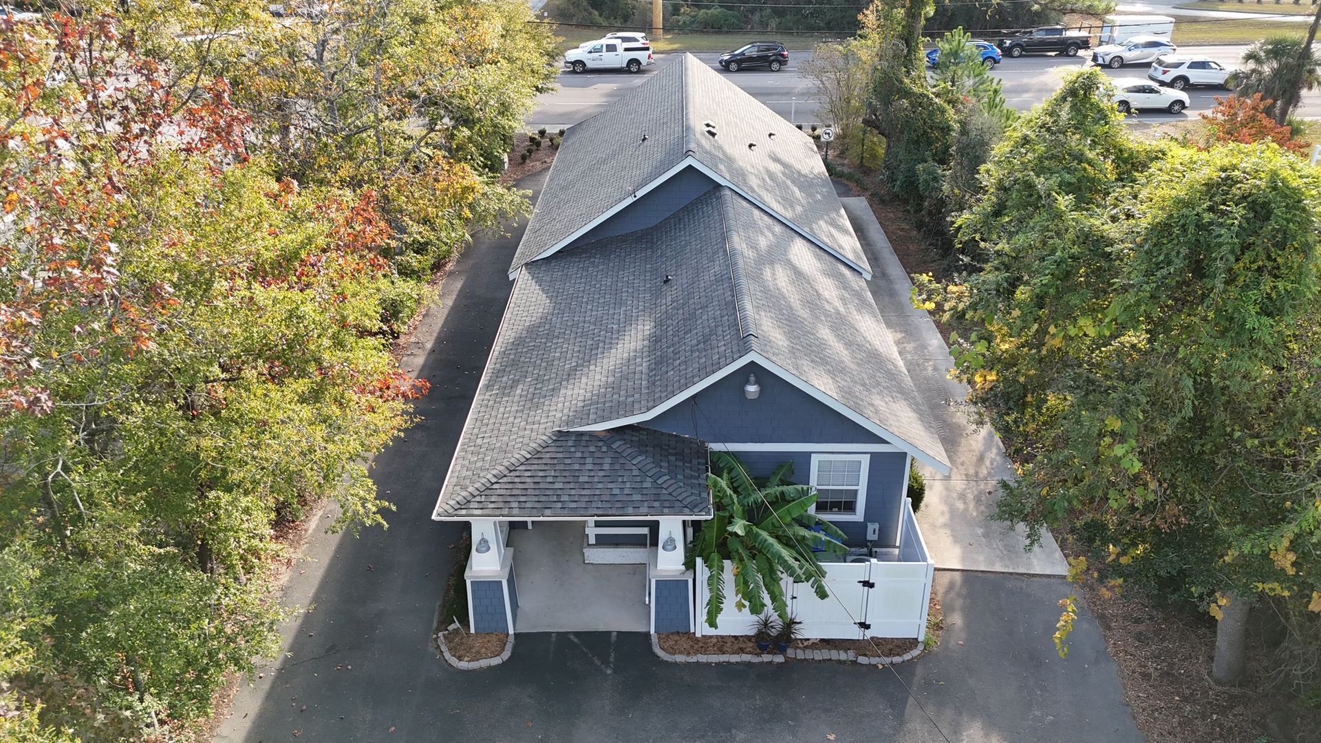 An aerial view of a house surrounded by trees and a driveway.