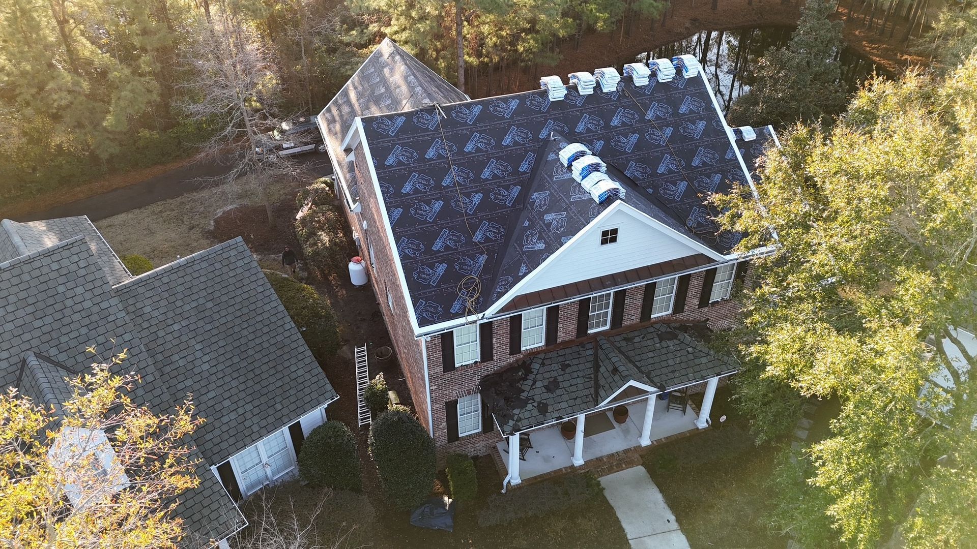 An aerial view of a house with a new roof being installed.