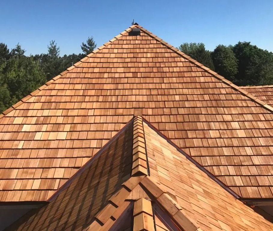 A slate roof with a blue sky and clouds in the background