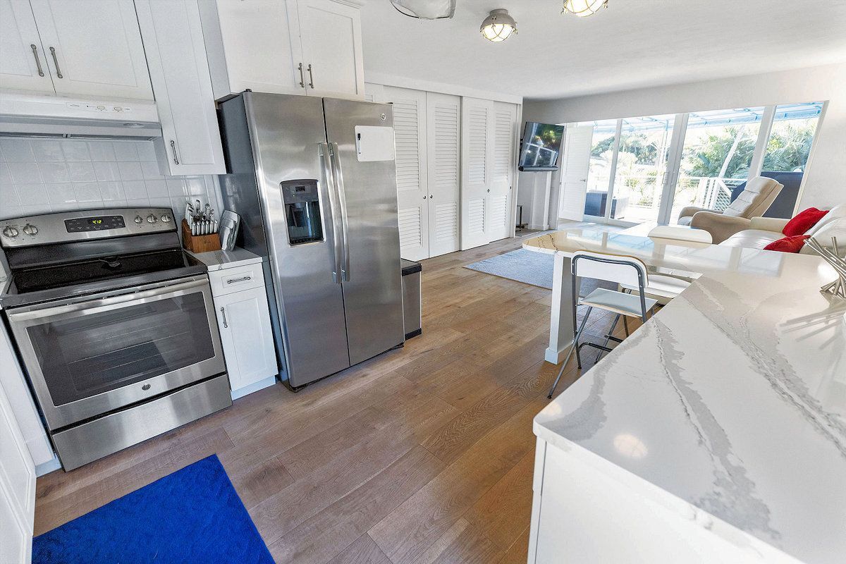 The Oasis Guest House kitchen with stainless steel appliances and white cabinets