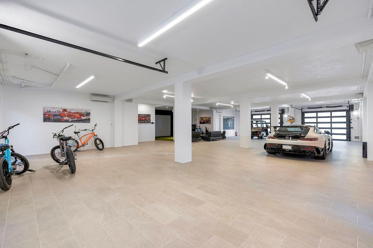 The Oasis, a large garage with bikes and a car parked in it .