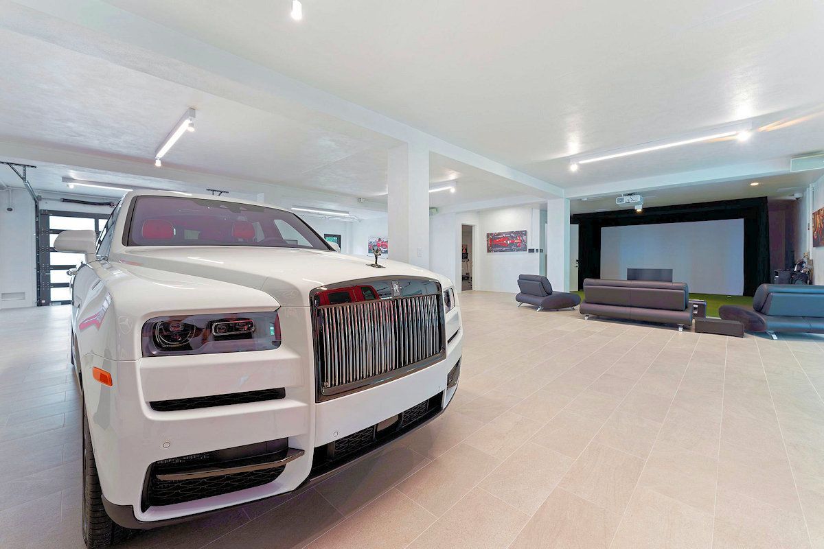The Oasis, a white Rolls Royce is parked in a garage.