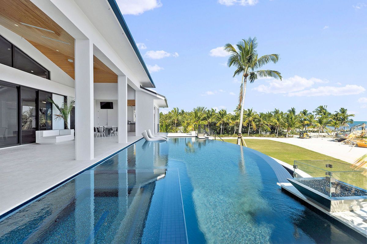 The Oasis Main House Living Areas including a large swimming pool with a palm tree in the background