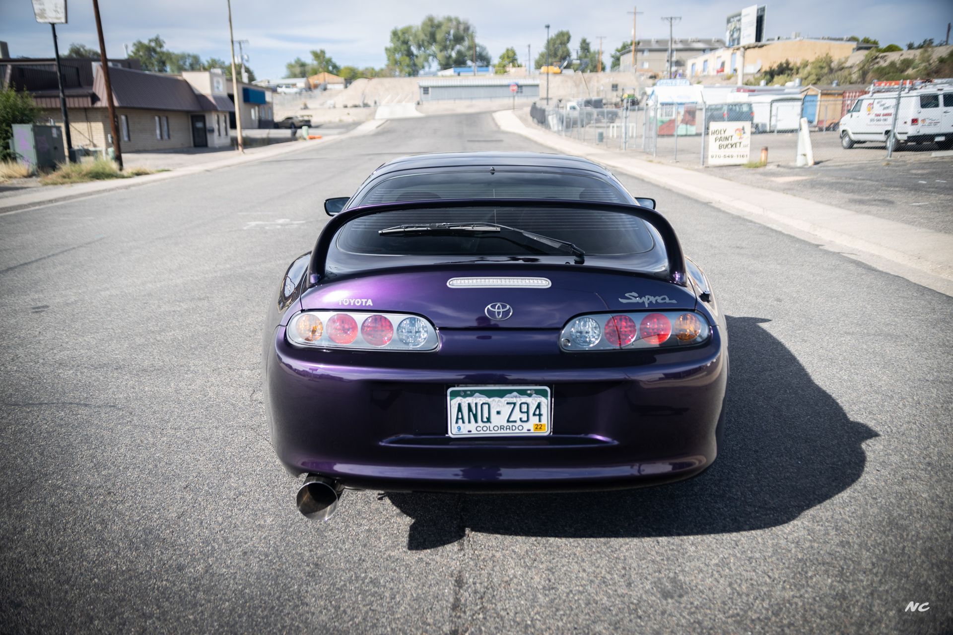 Purple Toyota Supra parked on an empty road, license plate 