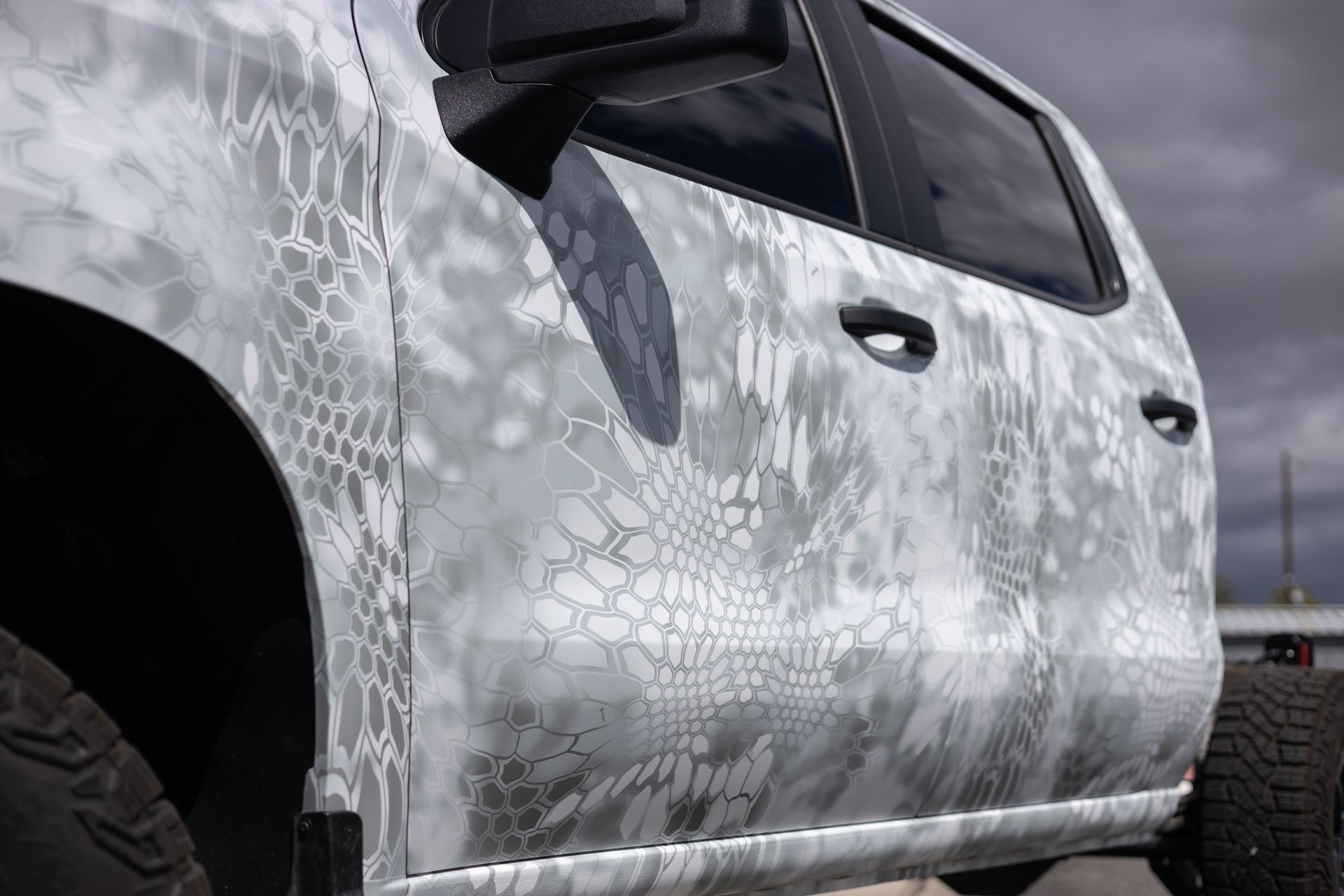 Gray truck with a unique camouflage pattern.