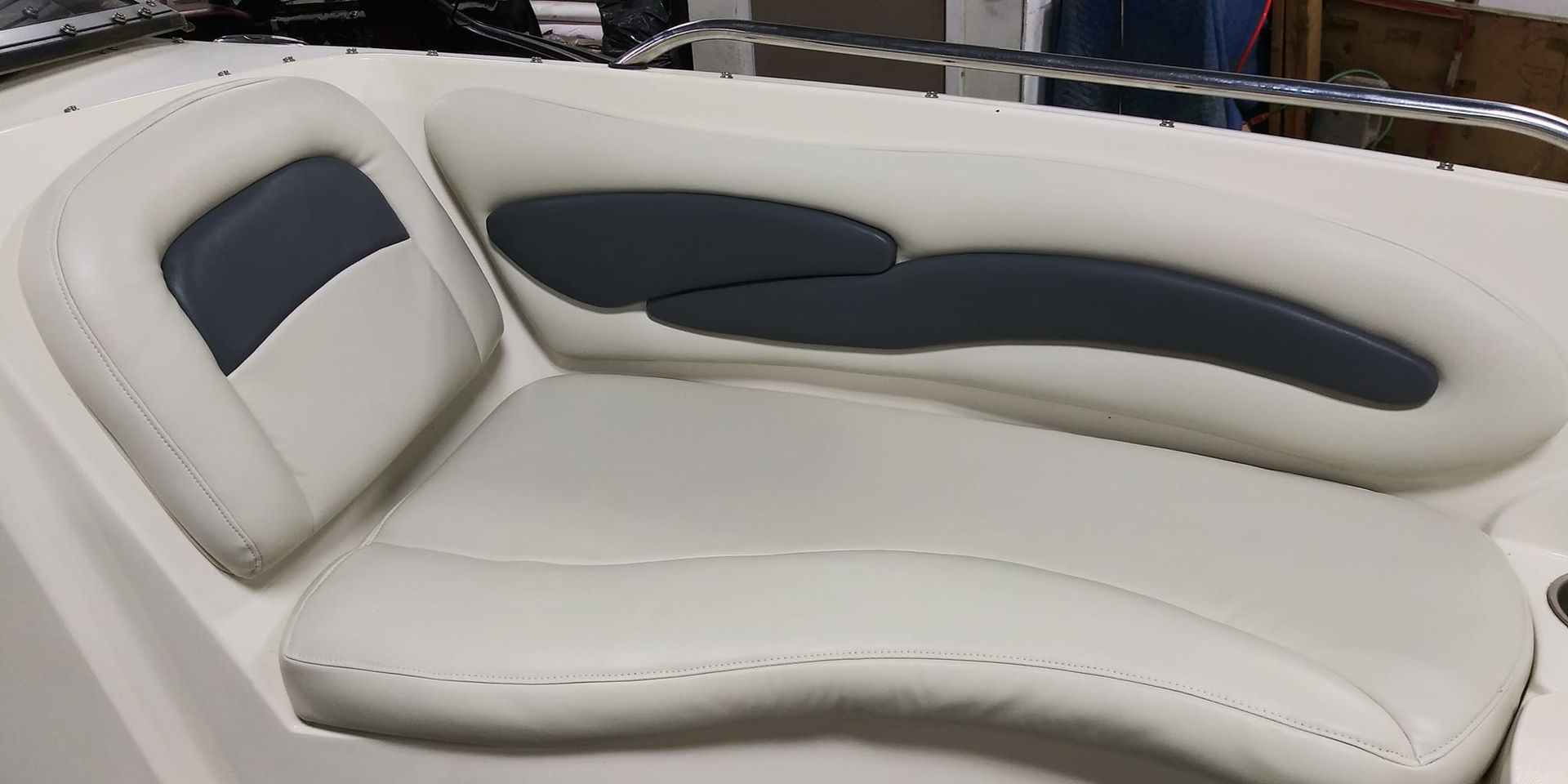 Light-colored padded boat seats with dark gray accent panels in a curved seating area.
