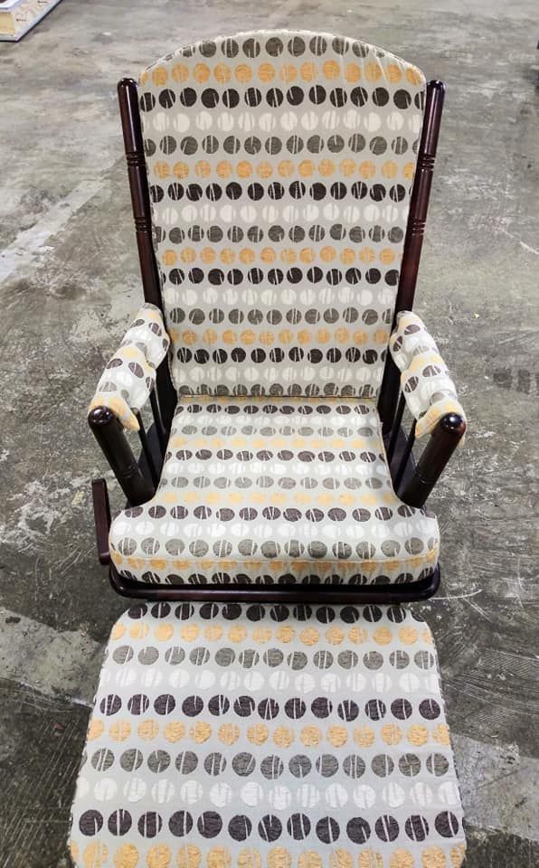 A wooden rocking chair and matching footstool upholstered in a light-colored fabric with rows of brown and gold circles.