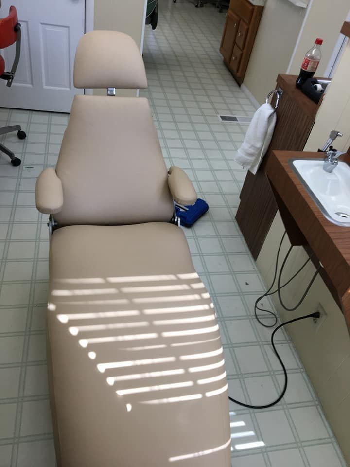 A dental chair in a bathroom next to a sink