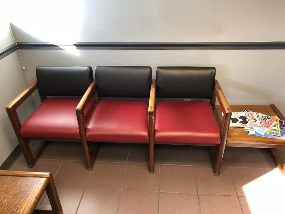 A row of red and black chairs in a waiting room.