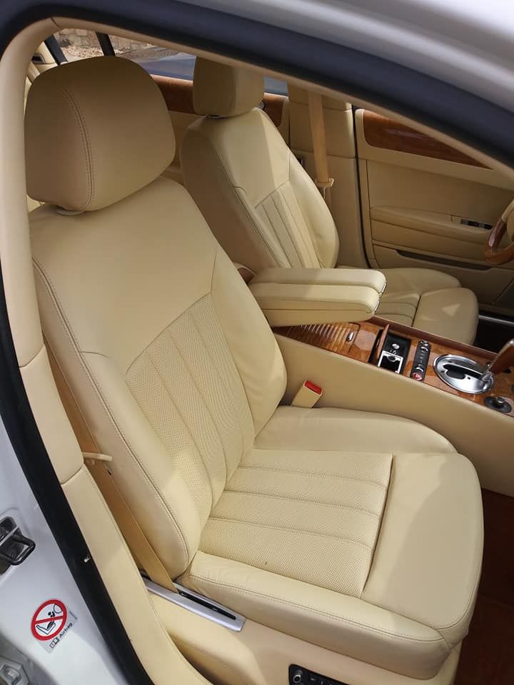 Luxury car interior featuring tan leather seats and a wood-trimmed center console.