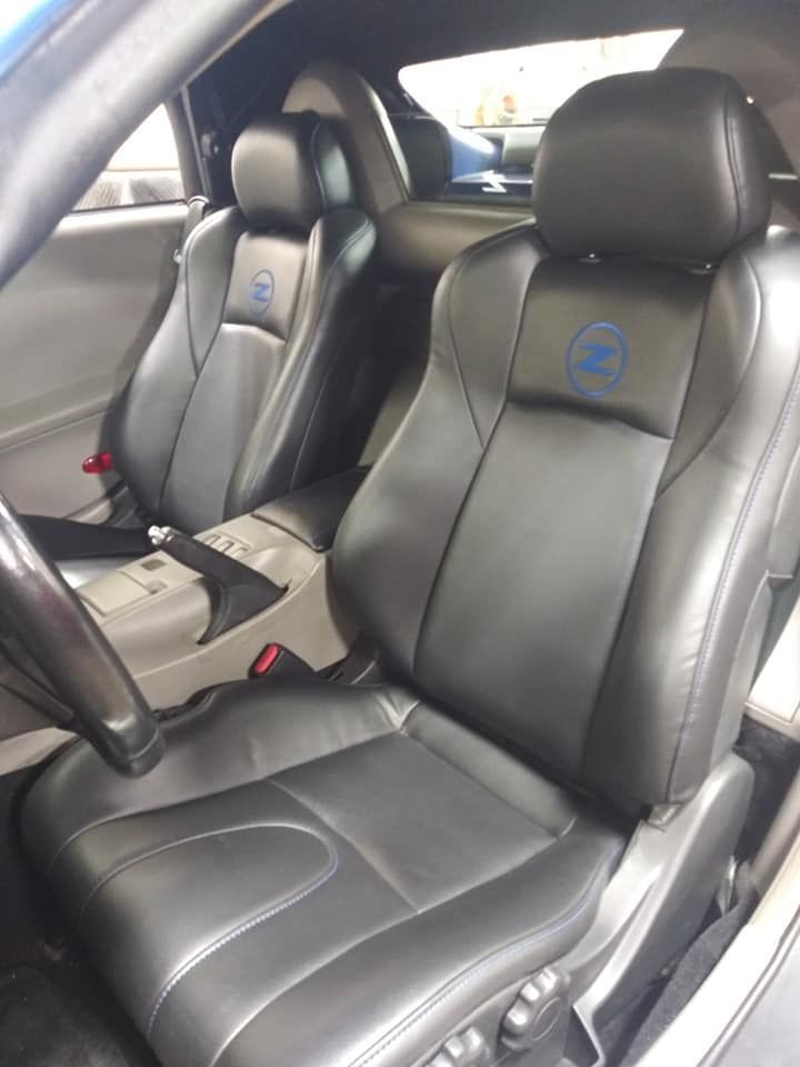 Interior view of a car with black leather bucket seats featuring a blue Z logo embroidered on the headrests.