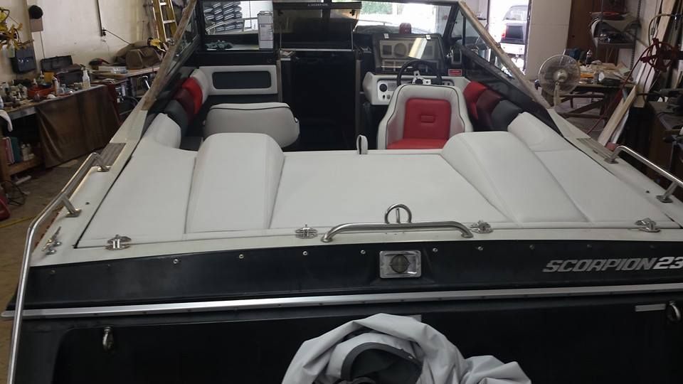 The rear view of a Scorpion boat featuring white and red cushioned seating, situated inside a storage facility.