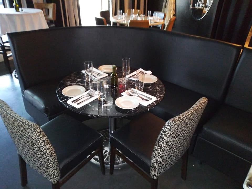 A round table with plates and glasses on it in a restaurant