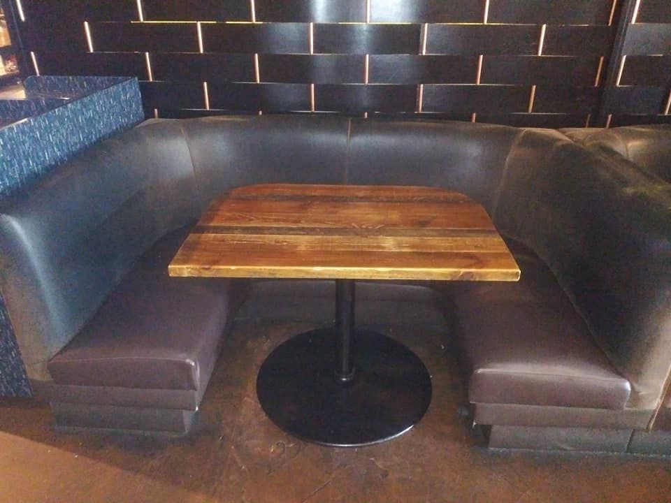A booth with a wooden table in the middle