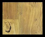 Wooden floorboards with visible grain and knots, in shades of light and medium brown.