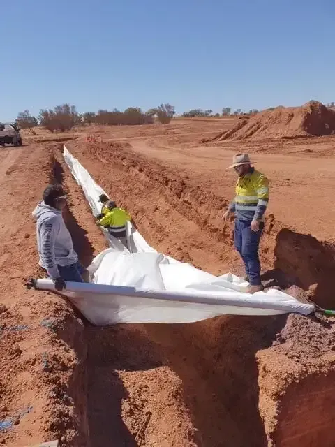 A Group of People Are Working on a Pipe in the Dirt — ASPLUM & CIVIL In Alice Springs, NT