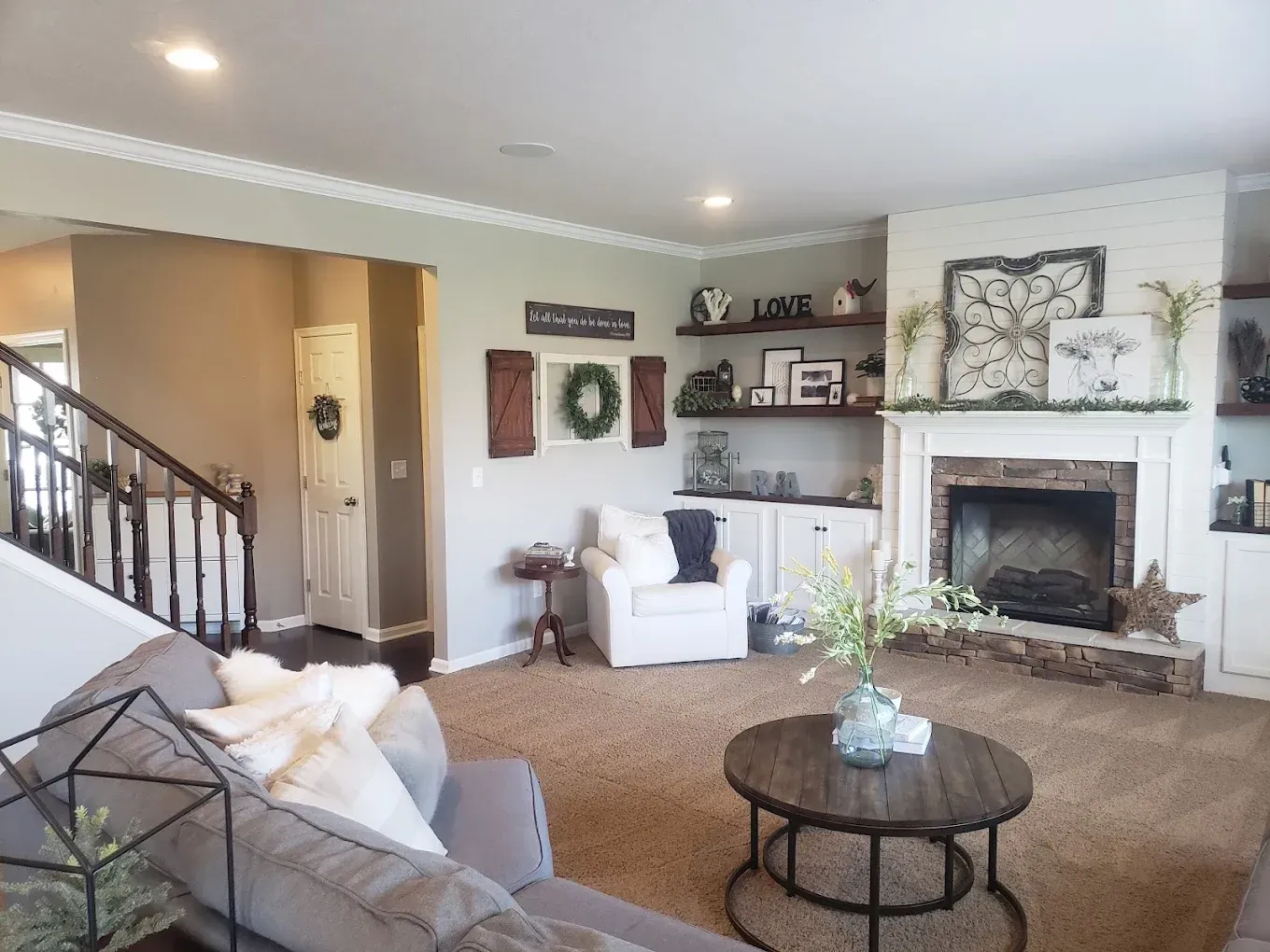 Cozy living room with fireplace, built-in shelves, sofa, and round coffee table.