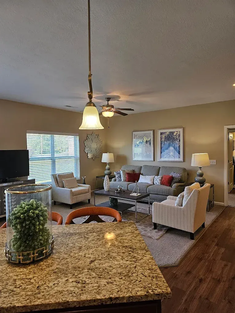 Living room with gray sofa, armchairs, coffee table, and tan walls.