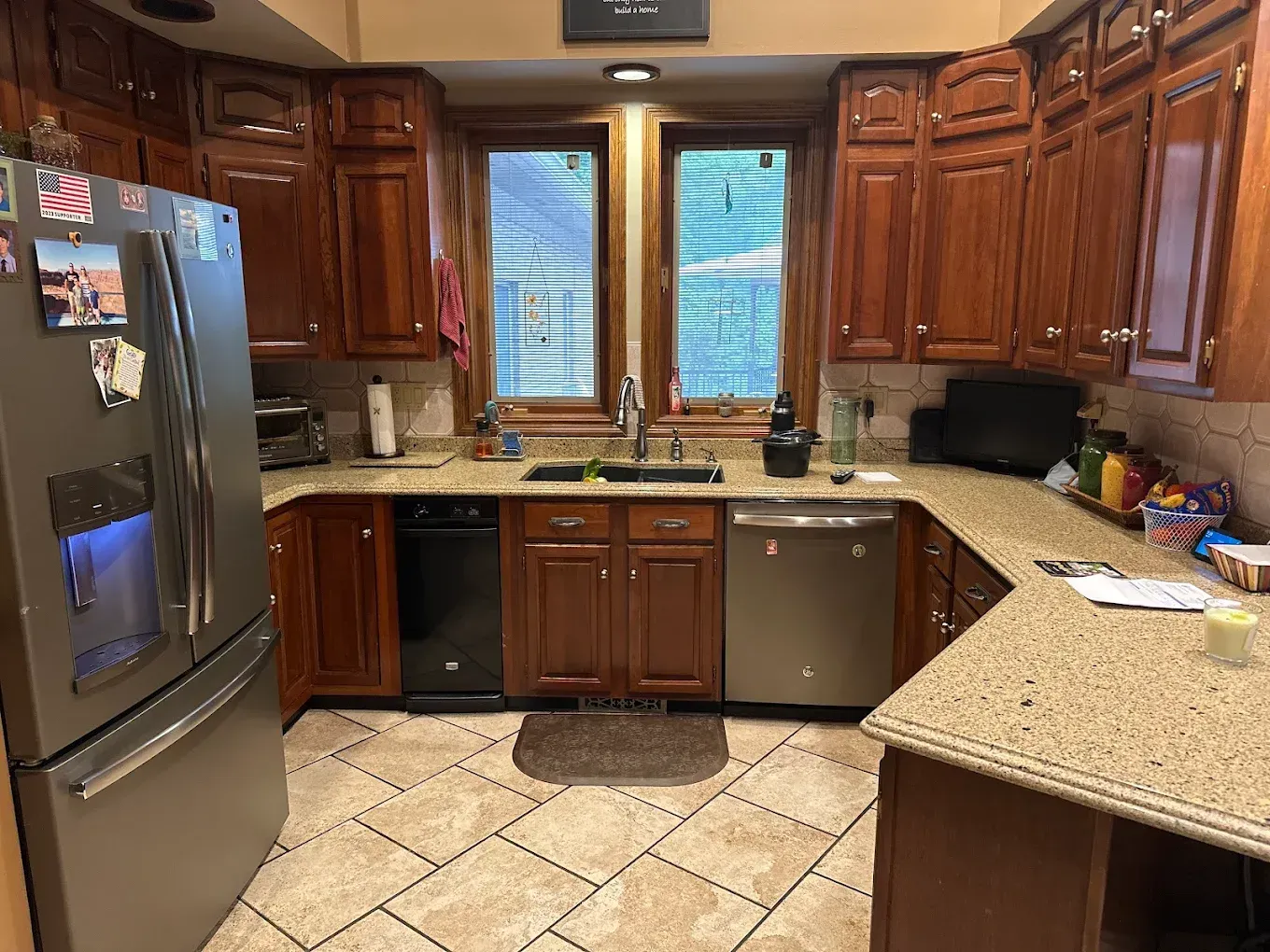 Kitchen with brown cabinets, stainless steel appliances, and beige countertops and flooring.