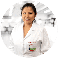 Mulher de jaleco branco sorrindo em um consultório médico bem iluminado.