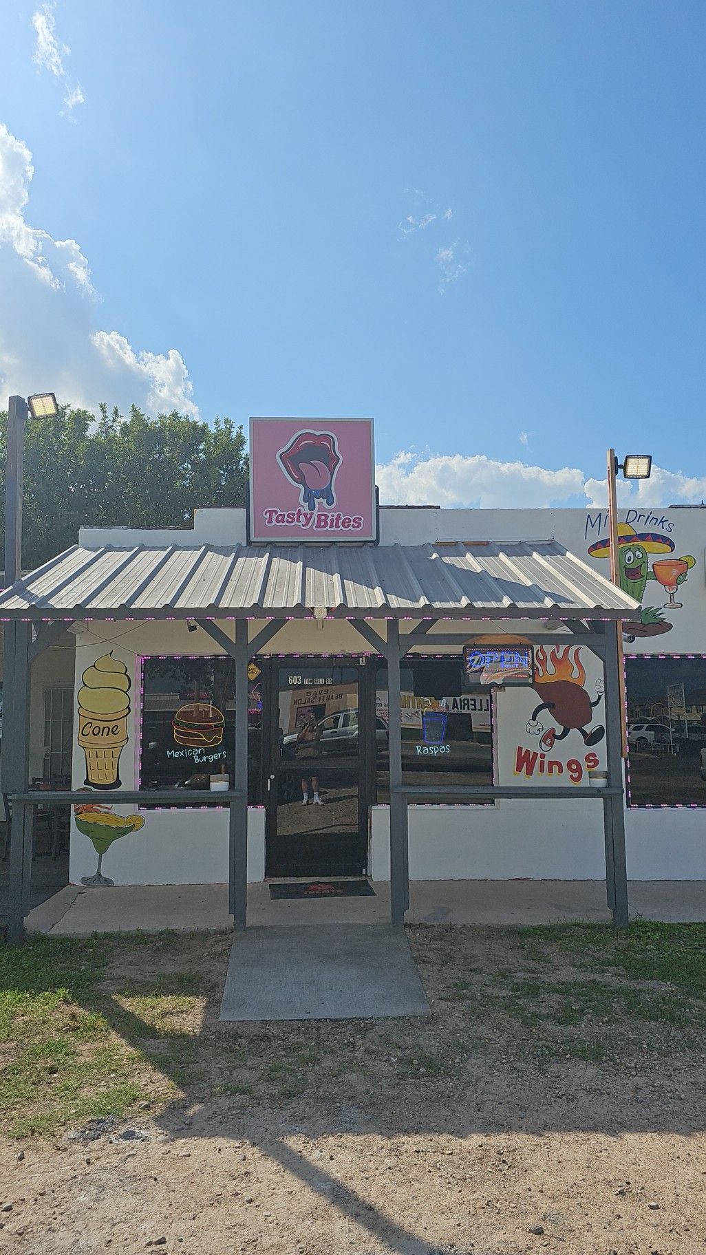 The front of a restaurant with a sign that says Tasty Bites on it.