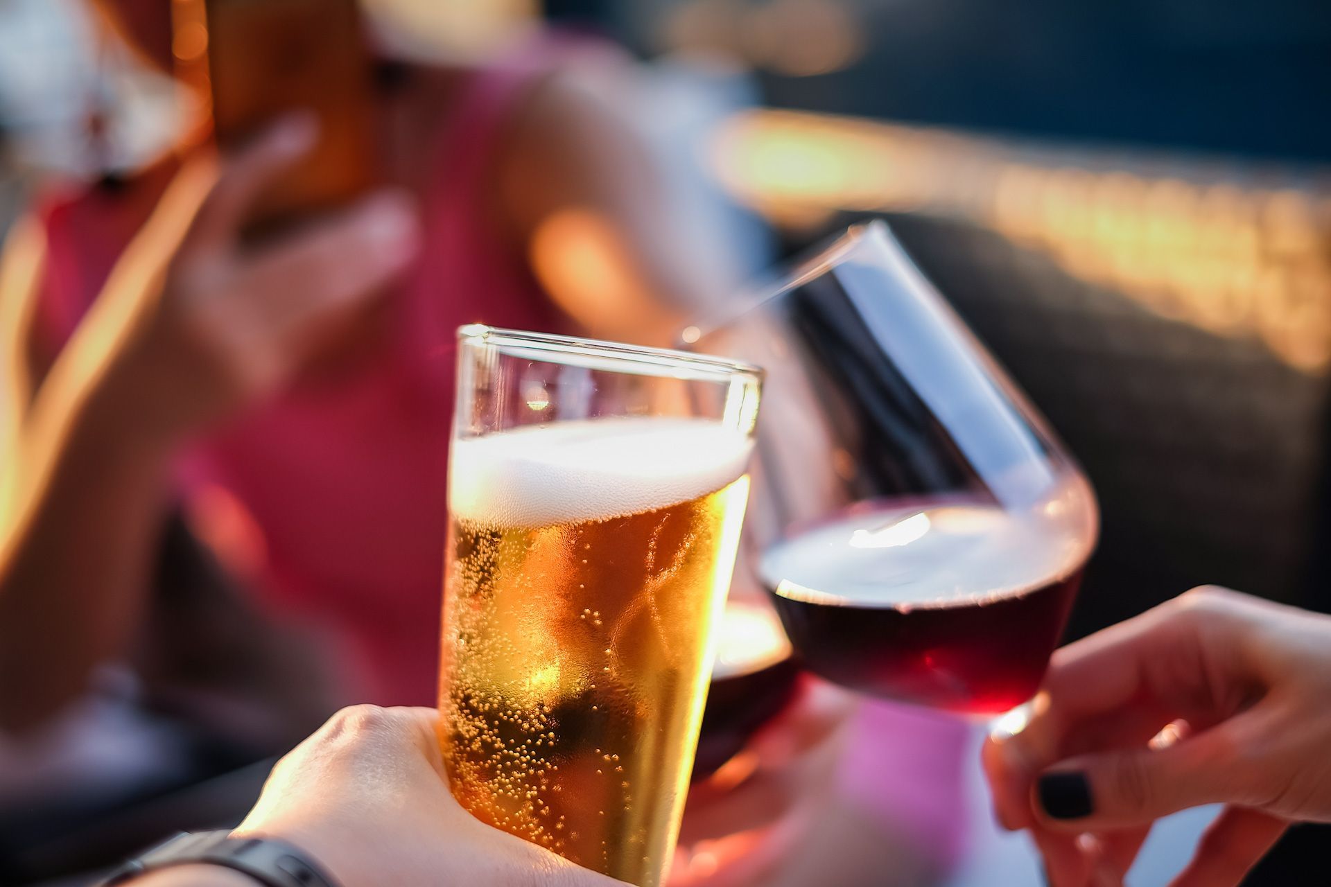 A group of people toasting with beer and wine glasses