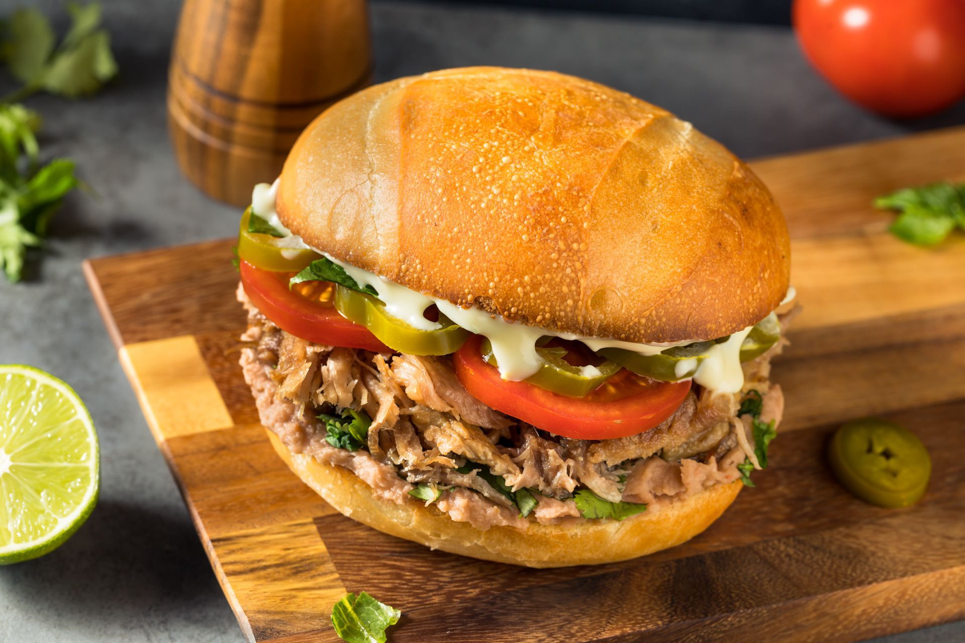 Two hamburgers are sitting on a wooden cutting board.
