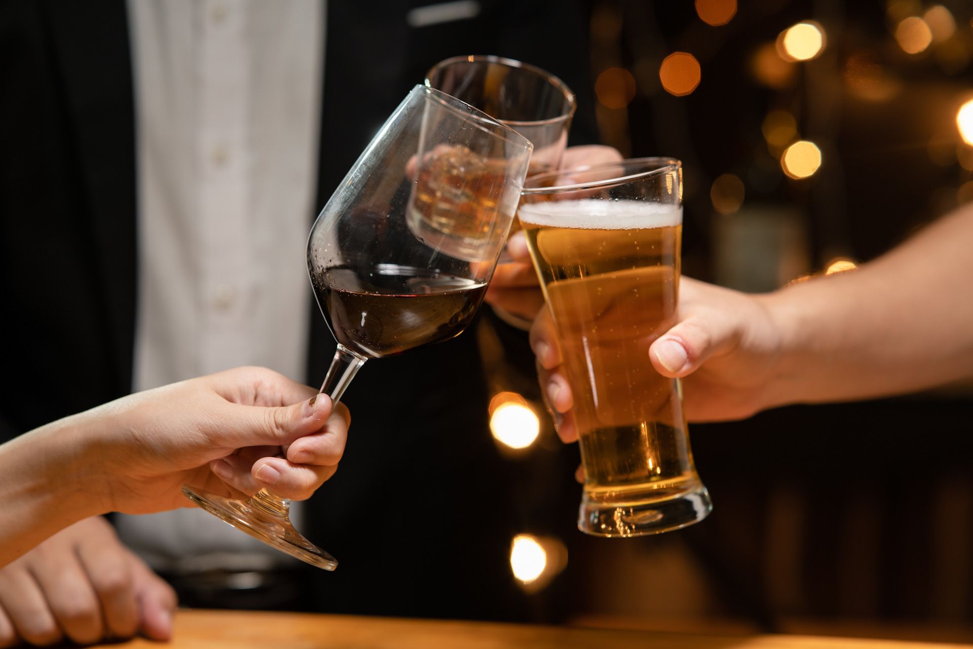 A group of people are toasting with wine and beer glasses.