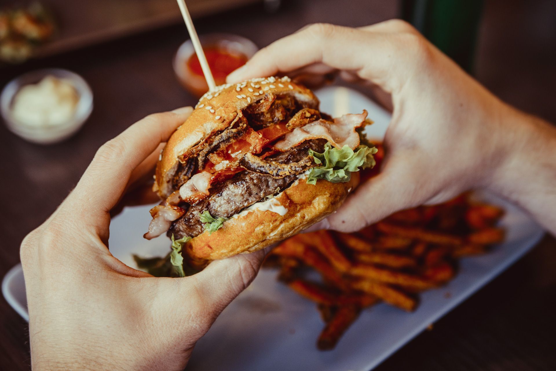 A person is eating a hamburger and french fries at a restaurant.