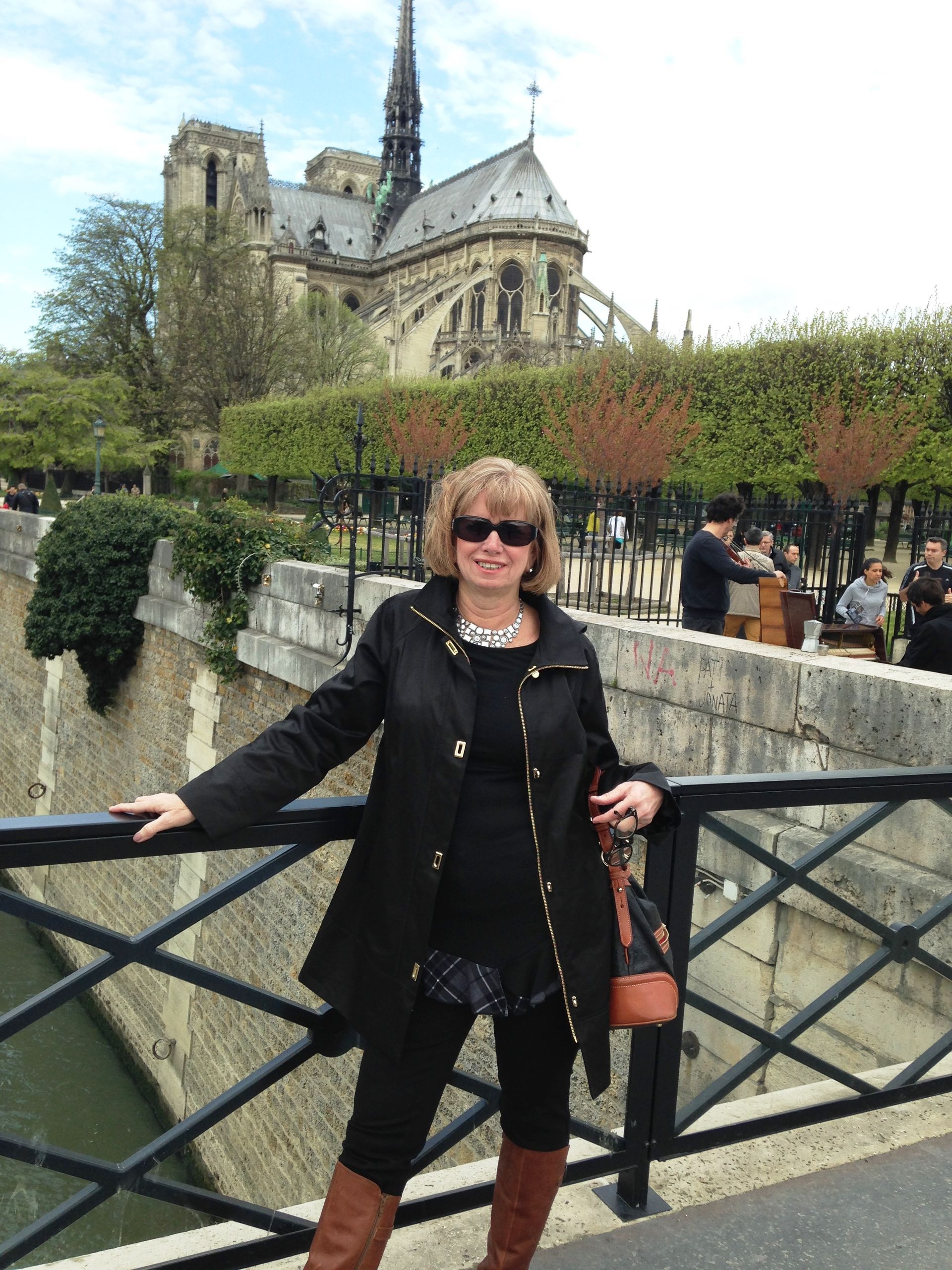 women standing in front of cathedral A woman standing on a bridge with a cathedral in the background