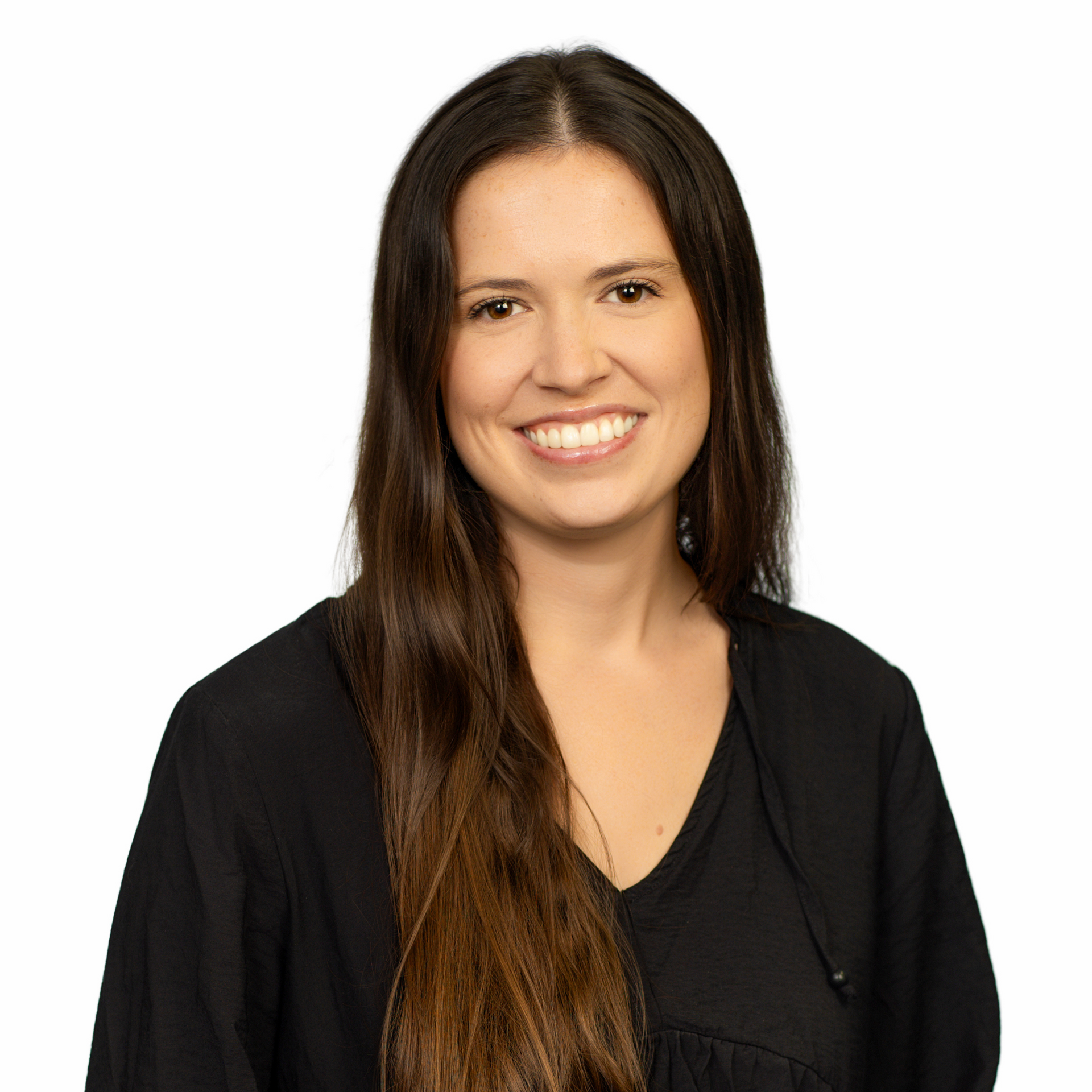 A woman with long brown hair is smiling for the camera.