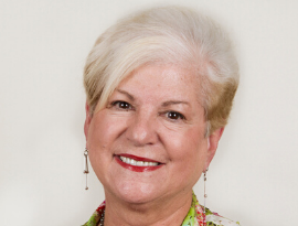 A woman with white hair and red lips is smiling for the camera.
