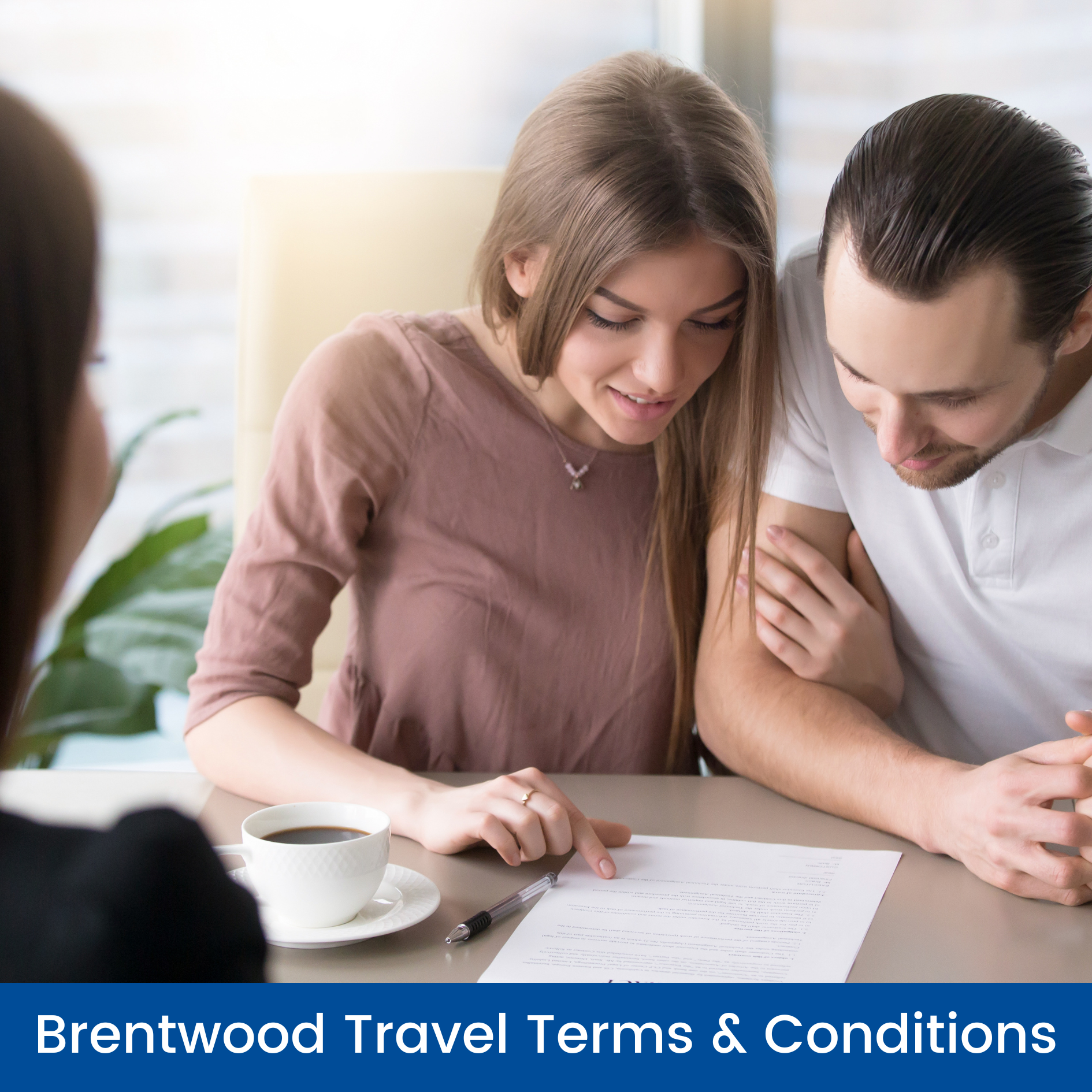 A man and a woman are sitting at a table looking at a piece of paper.
