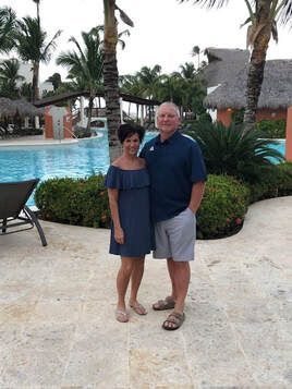 A man and a woman are standing next to each other in front of a swimming pool at Breathless Punta Cana