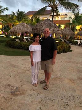 A man and a woman are standing next to each other on a beach.