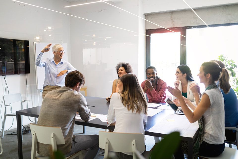 Group of people happily having a meeting | Elgin, IL | 'I' in Team Series By IA Business Advisors