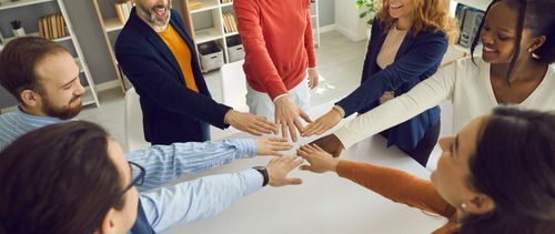 Group of people getting their hands together | Elgin, IL | 'I' in Team Series By IA Business Advisors