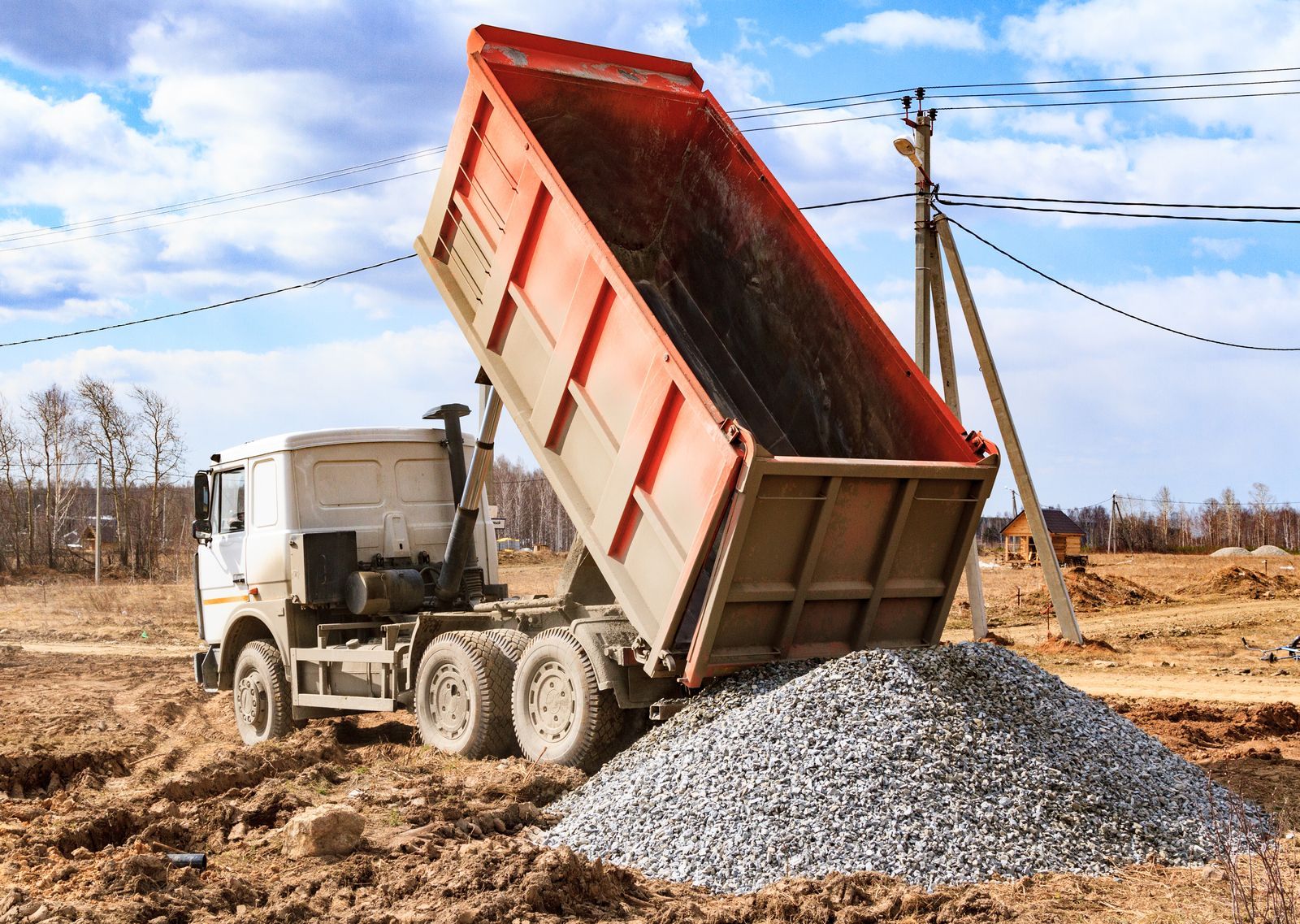 Dump truck unloading gravel at a construction site