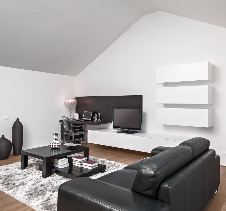Modern living room with black leather sofa, white shelves, coffee table, TV, and dark accent wall