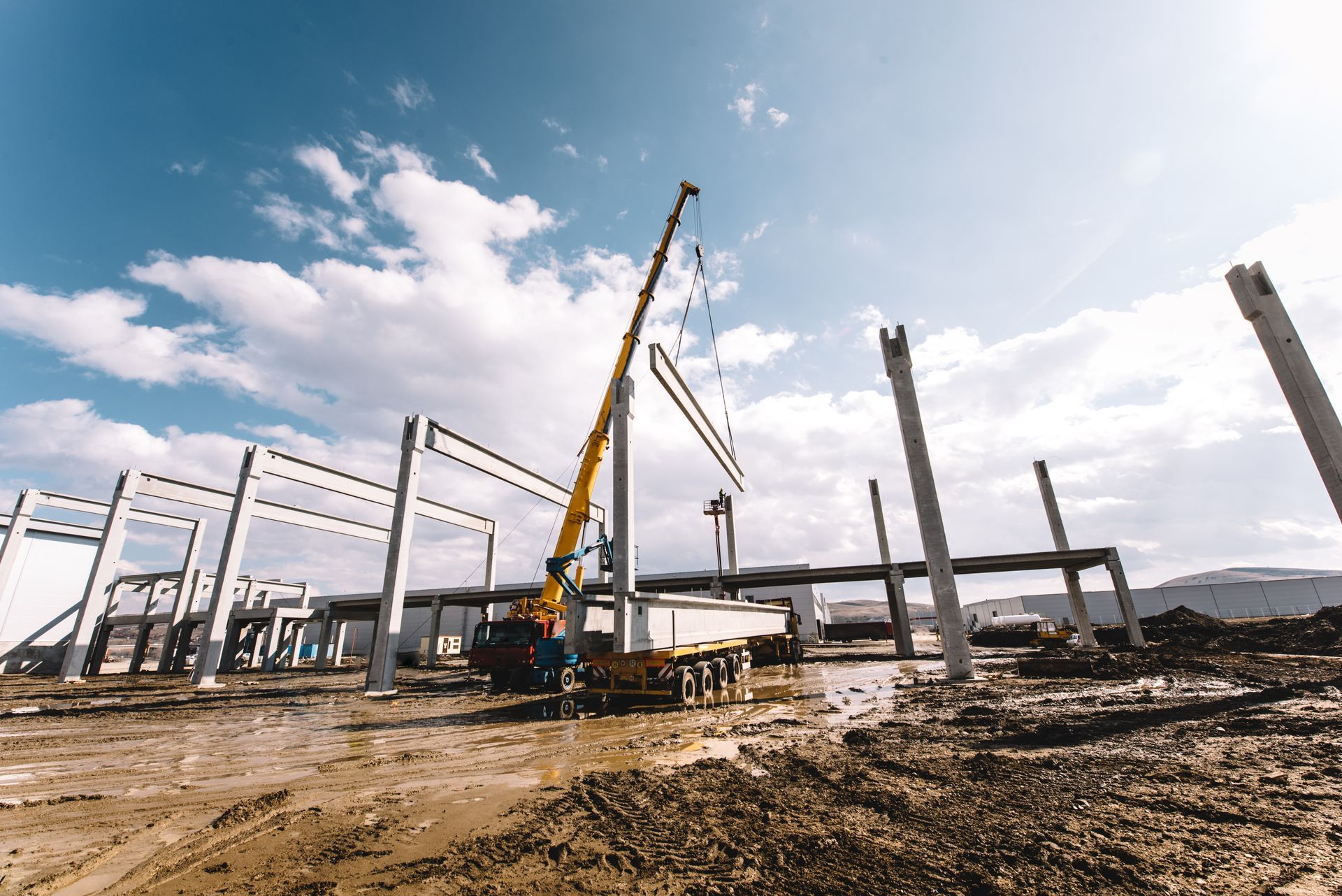 Construction site with cranes and steel framework under a bright sky