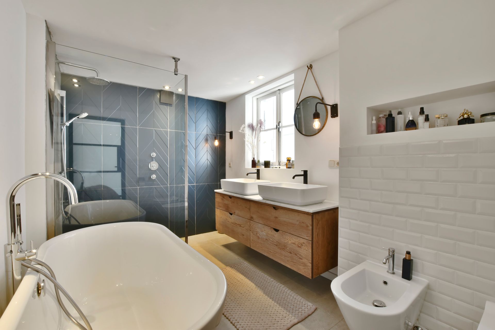 Modern bathroom with freestanding tub, glass shower, wooden vanity, and white tile walls