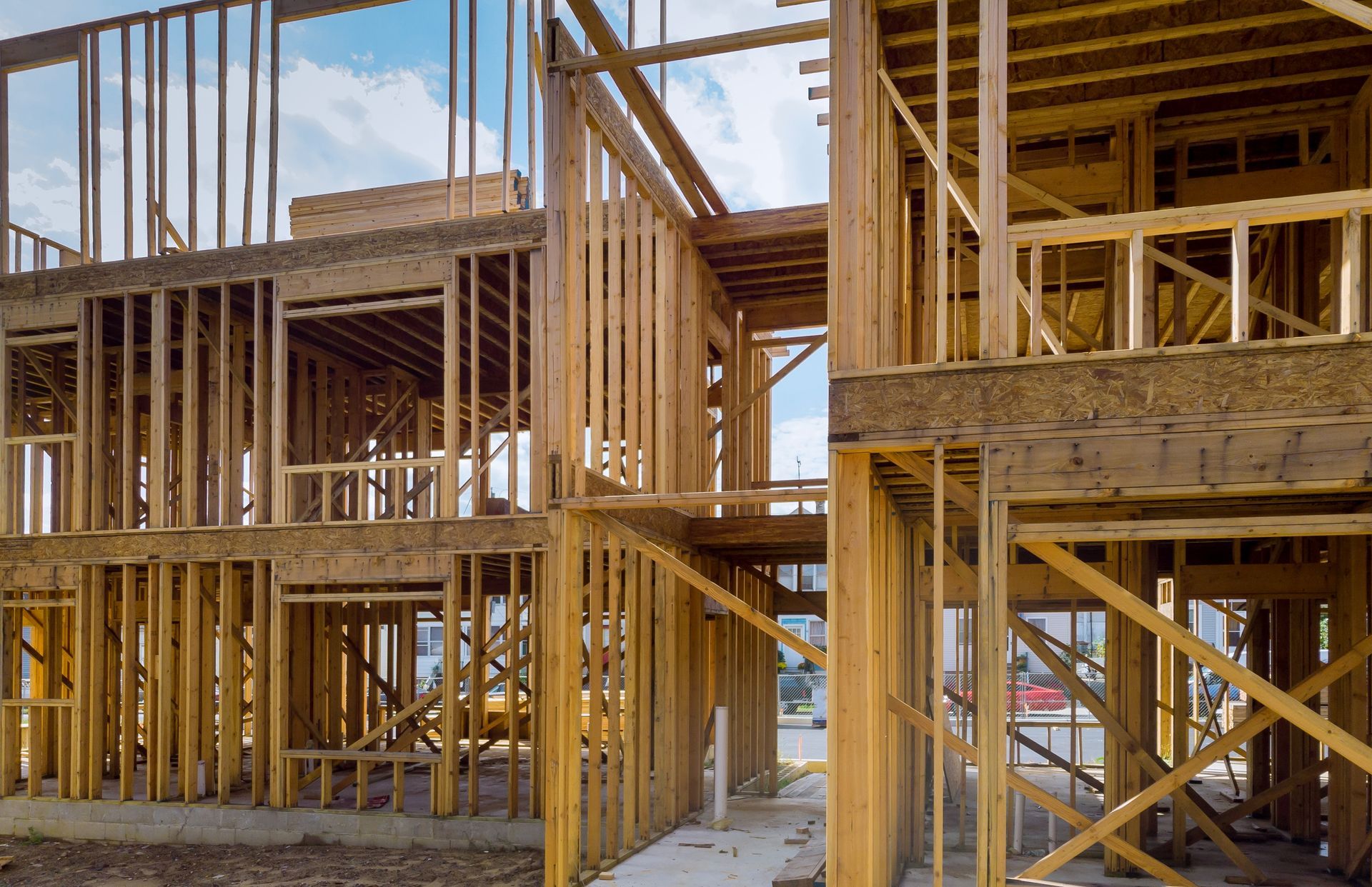 Wood-framed multi-story building under construction with exposed beams and scaffolding outdoors