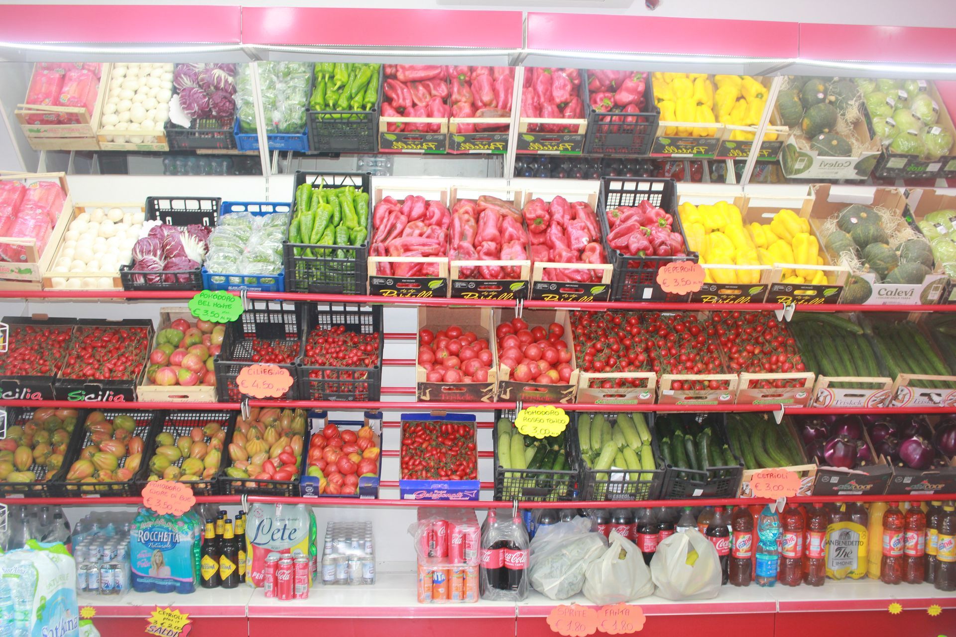 Uno scaffale del supermercato pieno di frutta e verdura