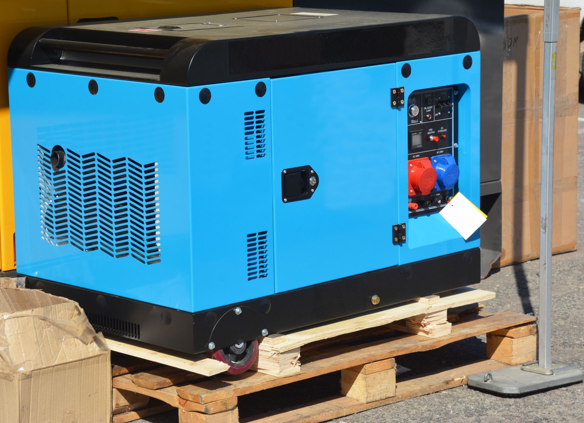 A blue generator is sitting on top of a wooden pallet.