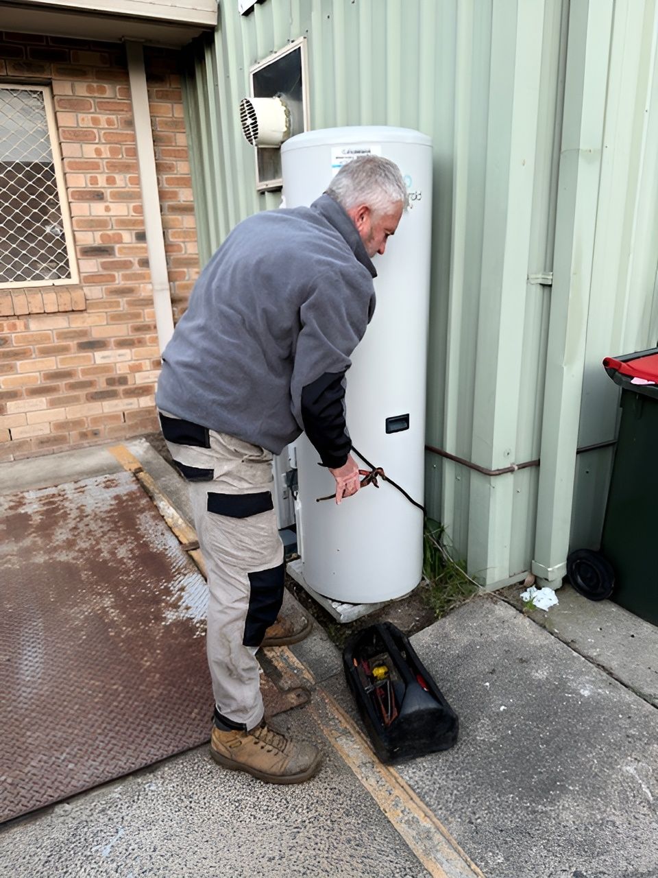 A Person is Cleaning a Sink With a Pair of Pliers — Accredited Plumbing in Ulladulla, NSW
