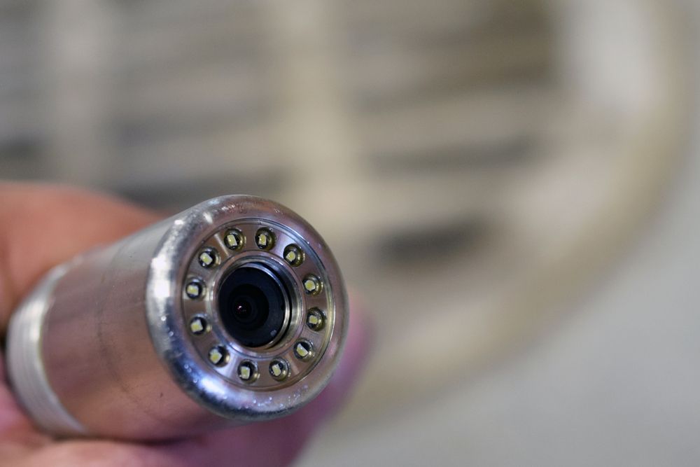 A Person is Holding a Camera in Their Hand — Accredited Plumbing in Mollymook, NSW