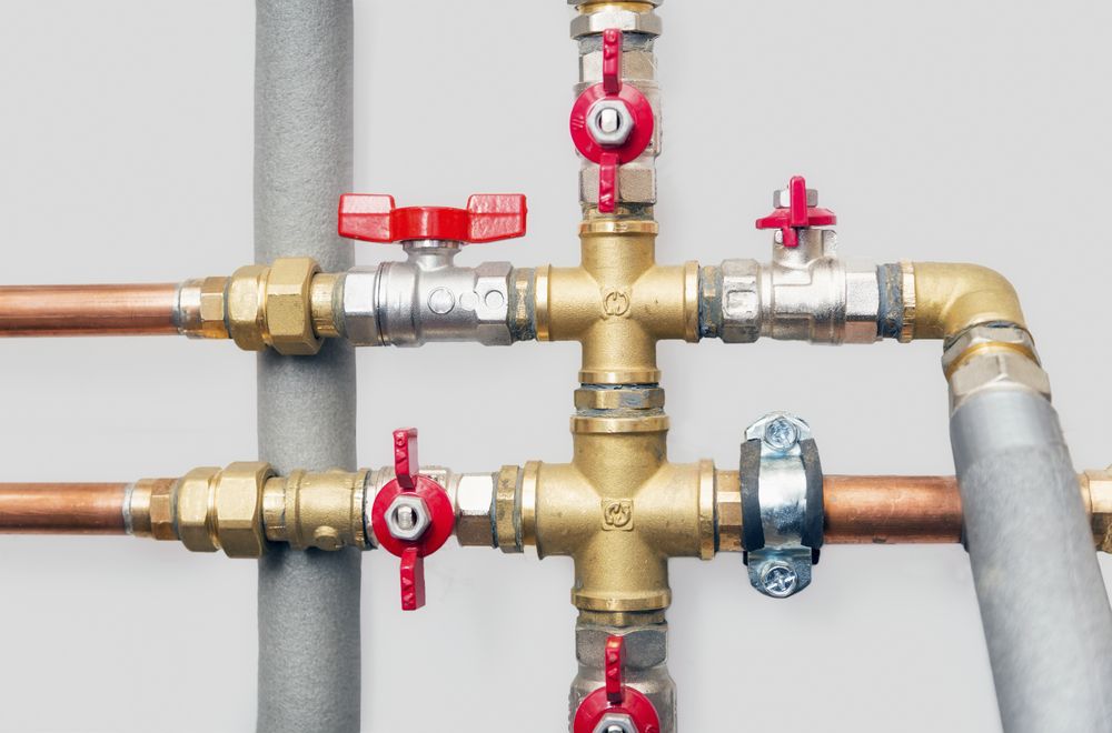 A Close Up of a Plumbing System With Copper Pipes and Red Valves — Accredited Plumbing in Kings Point, NSW